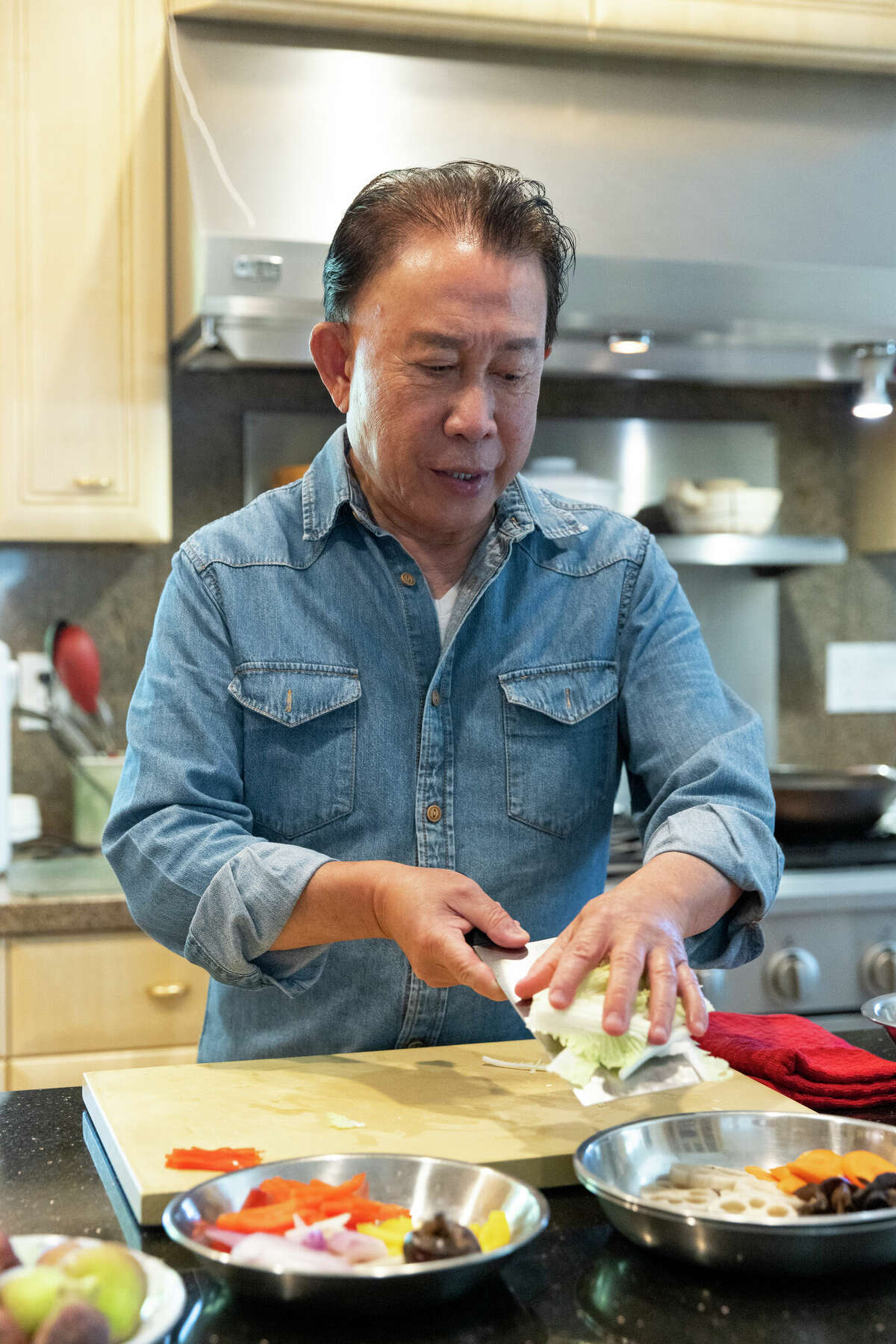 Chef Martin Yan chops vegetables for a stir-fry in his kitchen in Hillsborough.