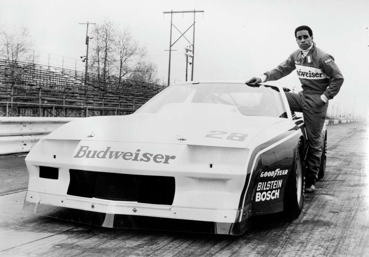 Potret setengah panjang pembalap Willy T Ribbs, anggota tim Budweiser Trans Am, berdiri di samping mobil balapnya, 1980. (Foto oleh Afro American Newspapers/Gado/Getty Images)