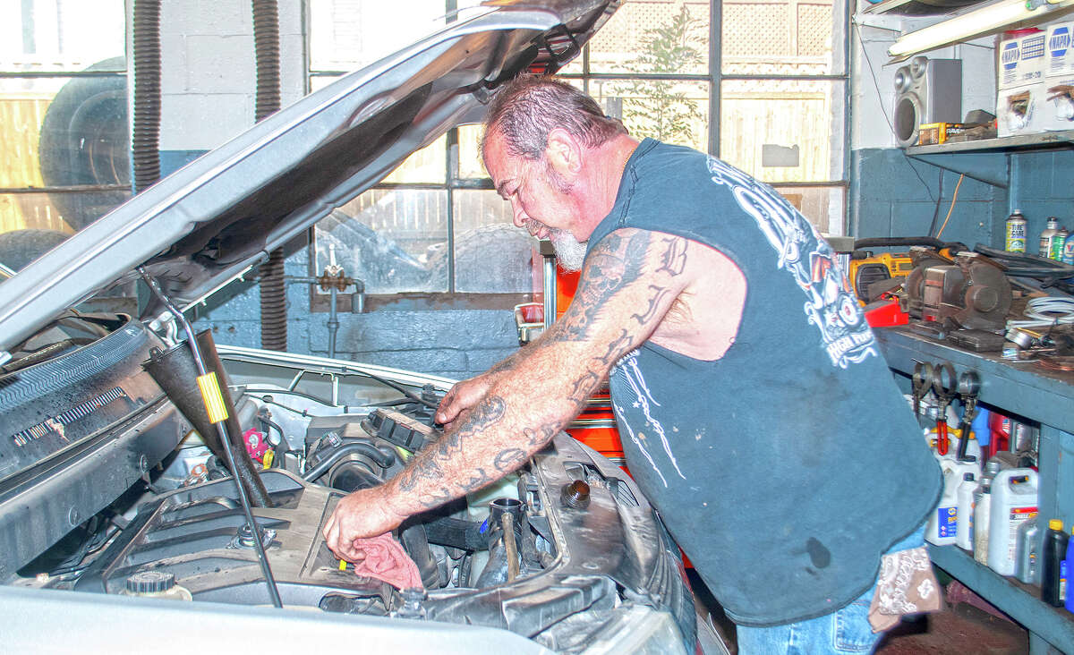 Dugan Auto and Tire mechanic Jeff Birdsell checks the oil on a car. With winter approaching, Birdsell said people should check oil, tire pressure and make sure antifreeze and other fluids are full.