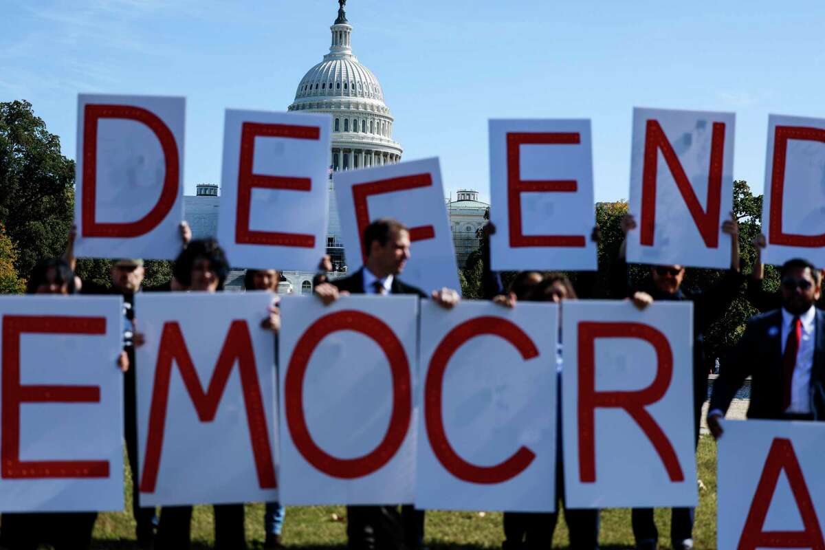 As voters begin to cast ballots, the threat to our democracy through election deniers looms large. Here, activists call to “Defend Democracy.”