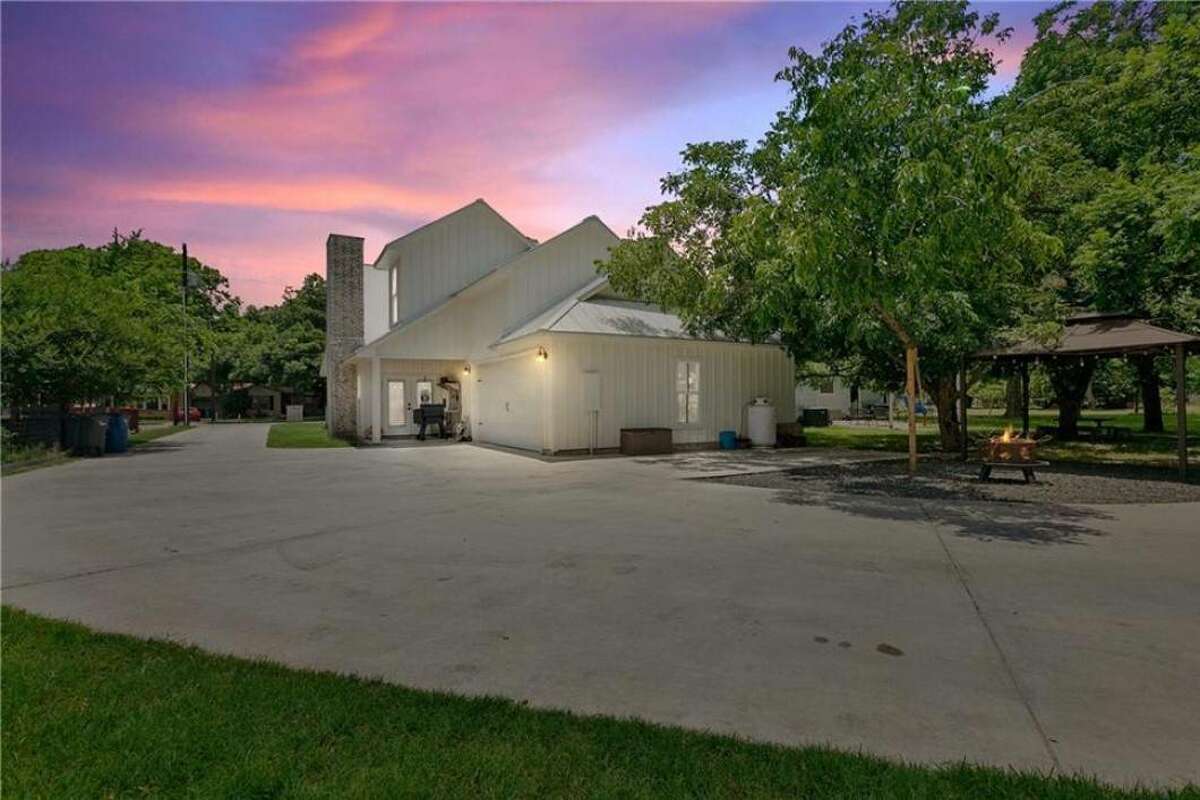 This custom paved driveway curves around the back.