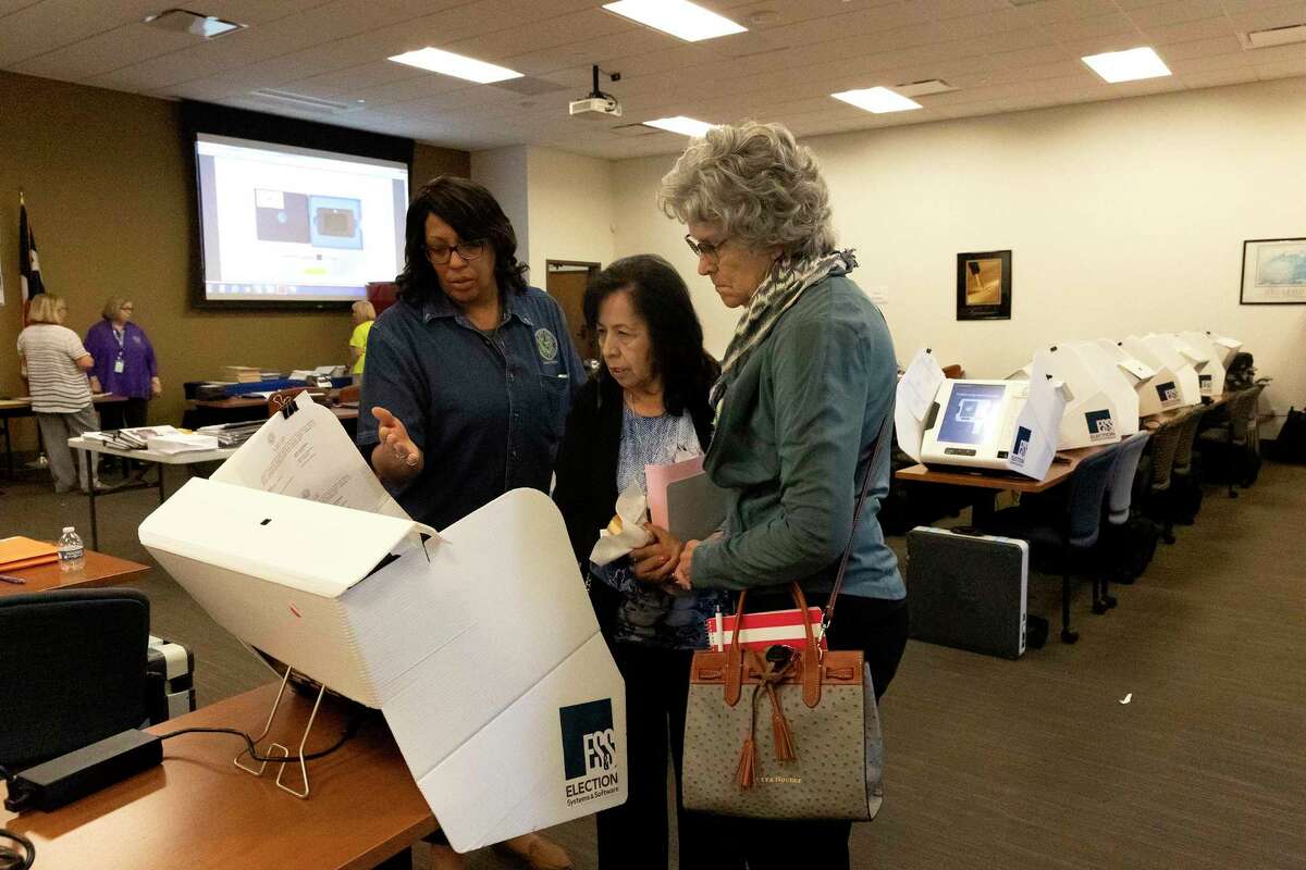 Training coordinator Mandisa Parker, left, shows Bexar County election judges the write-in procedures after a training for Bexar County election judges Friday morning.
