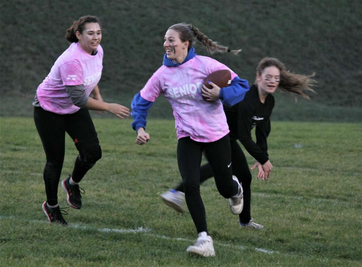Ashley VanAelst carries the ball up the field Friday during a powderpuff football game at Saber Stadium.