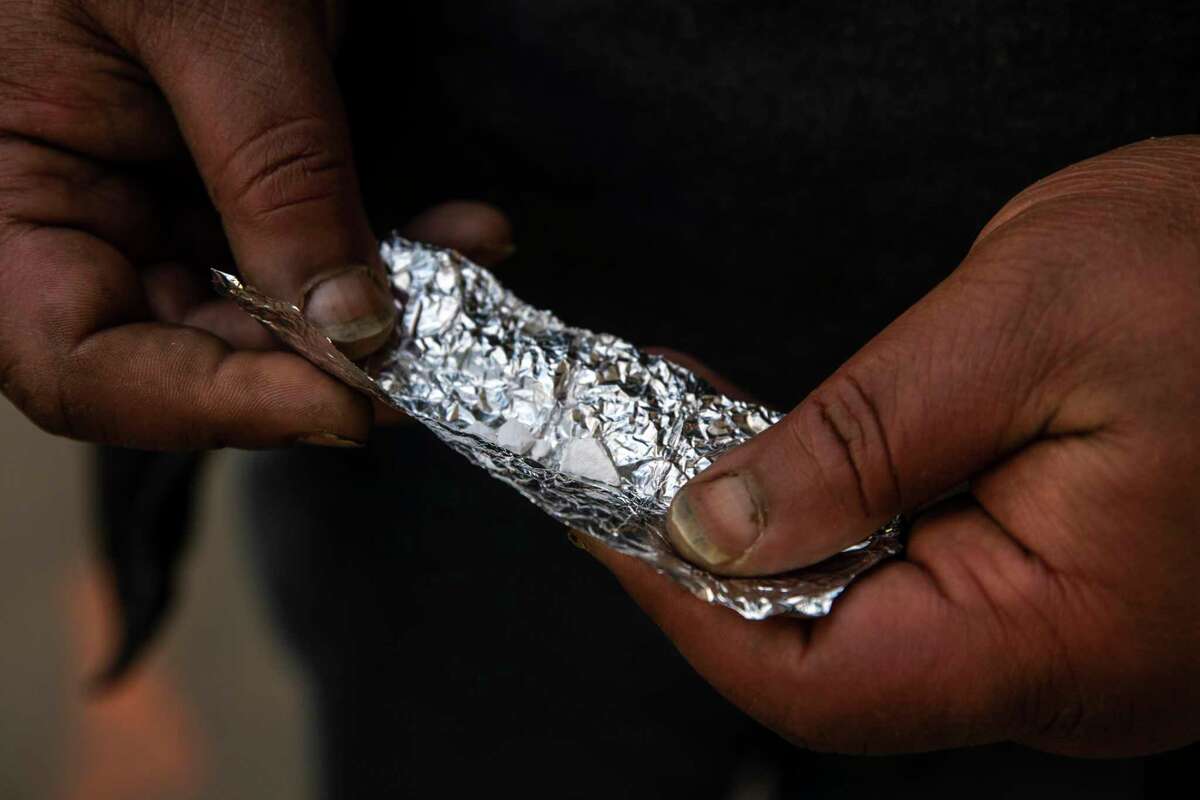 A man holds a chunk of fentanyl on a piece of foil purchased in the Tenderloin in San Francisco, California Tuesday, March 9, 2021.