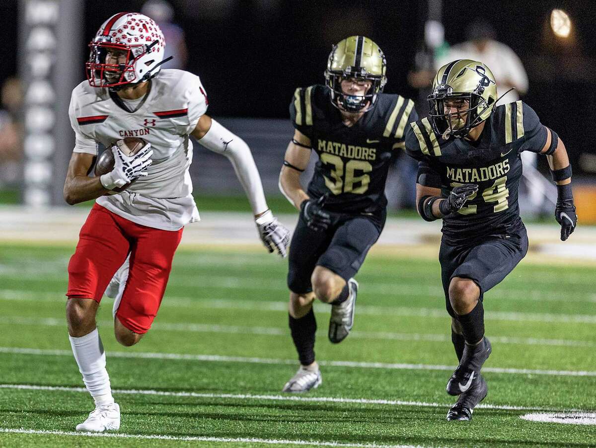 Canyon wide receiver Eli Adams is chased Friday night October 21, 2022, by Seguin’s Hayden Ross, center, and Ian Moreno during the first half of the Cougars’ game against the Matadors in Seguin.