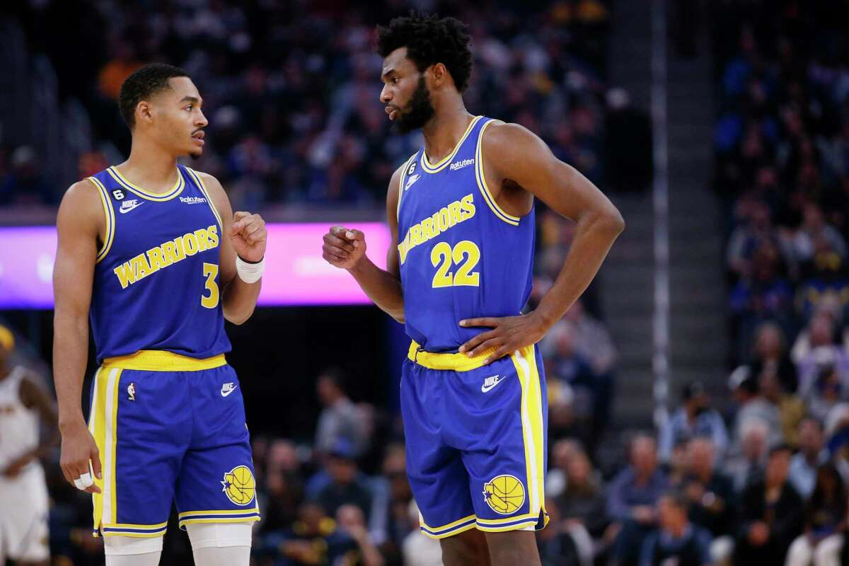 Golden State Warriors guard Jordan Poole (3) and Warriors forward Andrew Wiggins (22) fist bump in the first quarter of an NBA game against the Denver Nuggets at Chase Center in San Francisco, Calif., Friday, Oct. 21, 2022.
