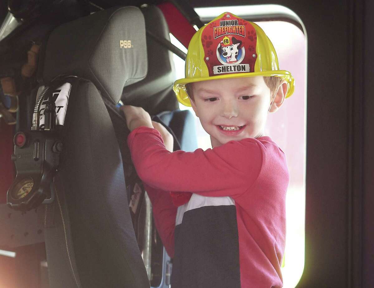 Mason Wilson, 5, enjoys climbing inside a fire truck at the annual Echo Hose Hook and Ladder Fall Festival at the fire station on Coram Avenue in Shelton, Conn. on Saturday, October 22, 2022.