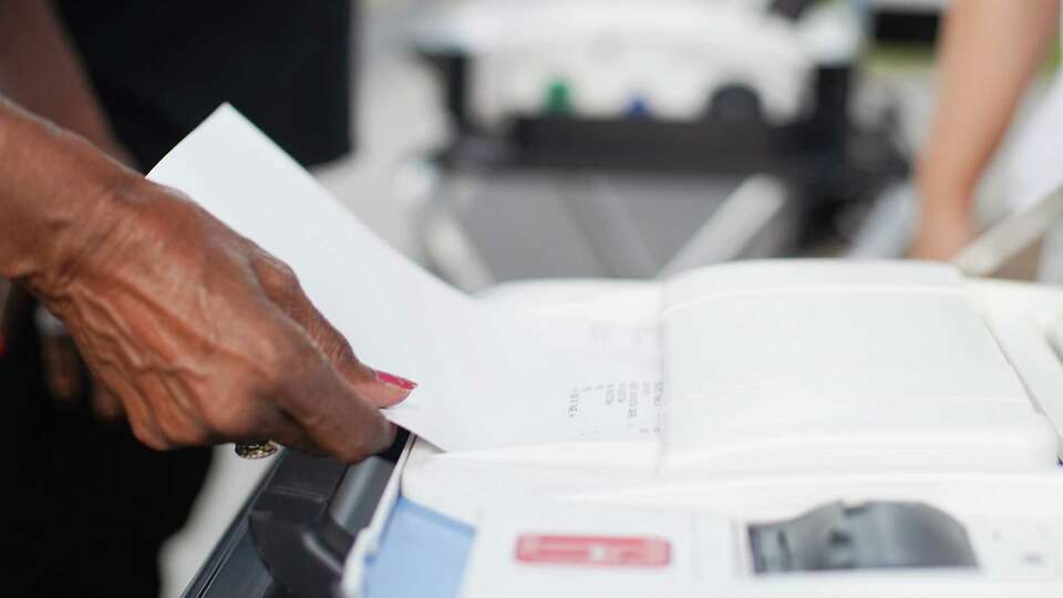 Alice Haynes feeds her practice ballot into a demo voting machine during an early-voting rally at Emancipation Park on Saturday, Oct. 22, 2022 in Houston. The event was hosted by League of Women Voters Houston along with other organizations to urge registered voters to get out and vote.