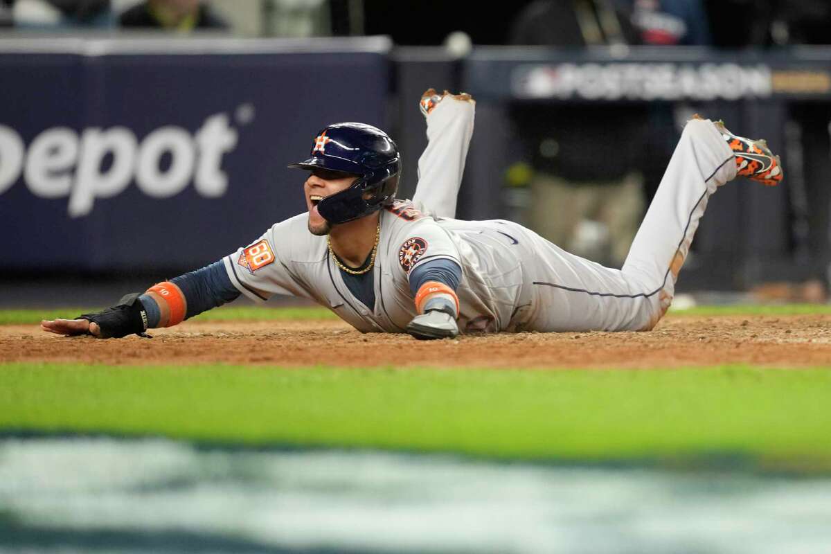 A jubilant Yuli Gurriel slides home with the Astros' final run, courtesy of Christian Vazquez's two-RBI single in the sixth, at Yankee Stadium on Saturday.