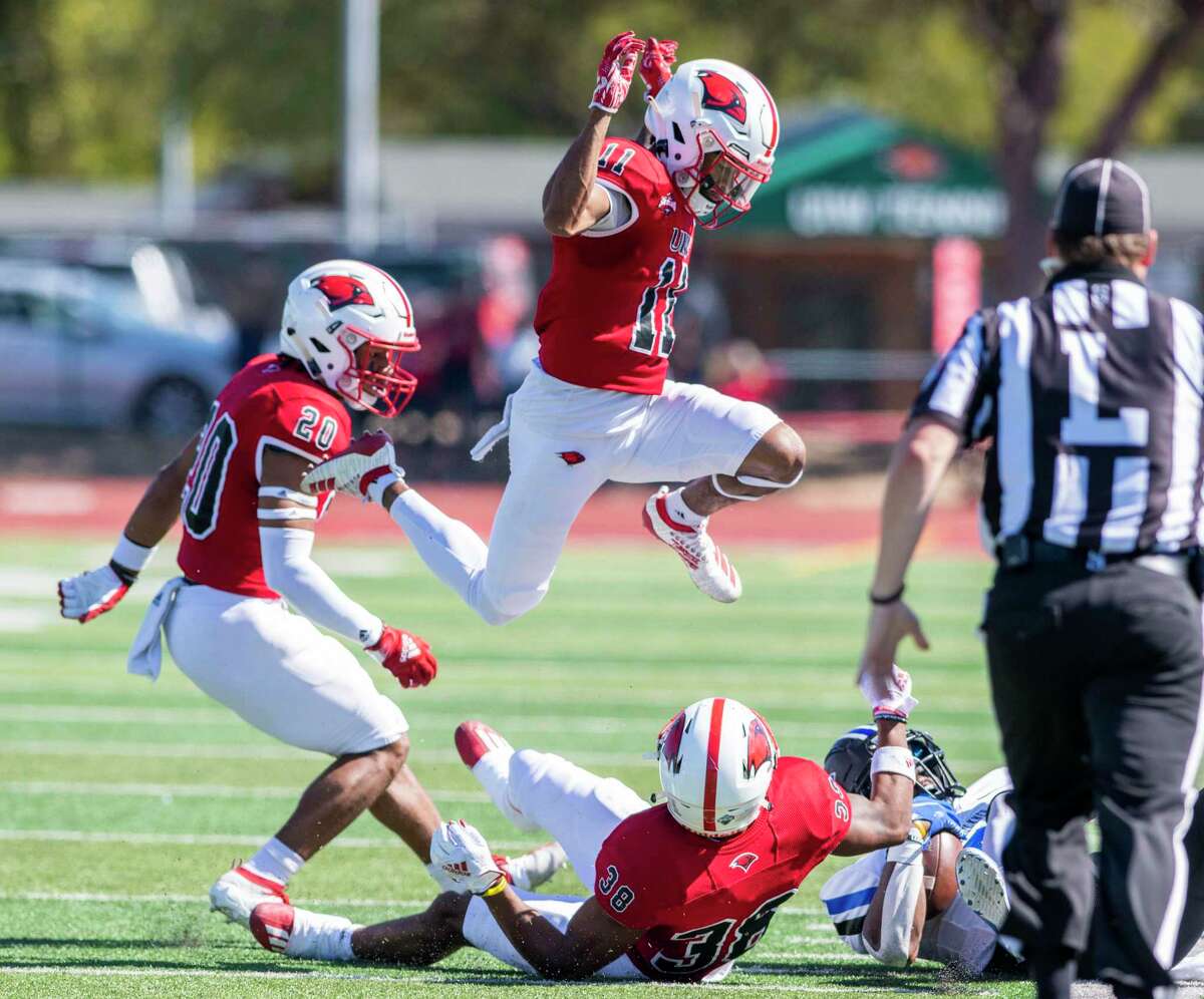 University of Incarnate Word’s Ce’Cori Tolds jumps over teammate running back Tyrese Brown after he tackled Faulkner running back Corinthian Cunningham during the first half on Saturday.
