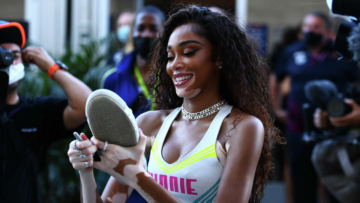 AUSTIN, TEXAS - OCTOBER 23: Winnie Harlow signs a shoe in the paddock during qualifying ahead of the F1 Grand Prix of the United States at Circuit of the Americas on October 23, 2021 in Austin, Texas.  (Photo by Clive Mason - Formula 1/Formula 1 via Getty Images)