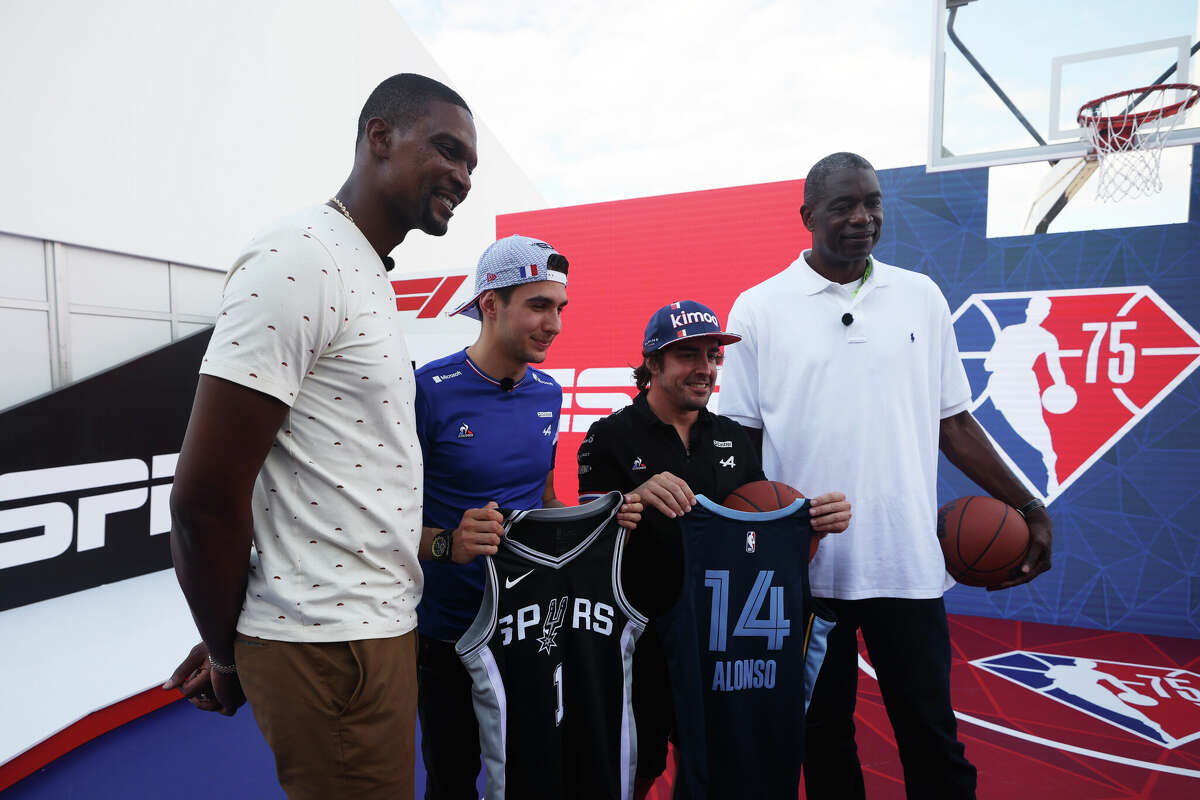 Fernando Alonso of Spain and Alpine F1 Team and Esteban Ocon of France and Alpine F1 Team pose for a photo with NBA legends Dikembe Mutombo and Chris Bosh after playing basketball on the NBA court in the Paddock during previews ahead of the F1 Grand Prix of the United States at Circuit of the Americas on October 21, 2021 in Austin, Texas.  (Photo by Chris Graythen/Getty Images)