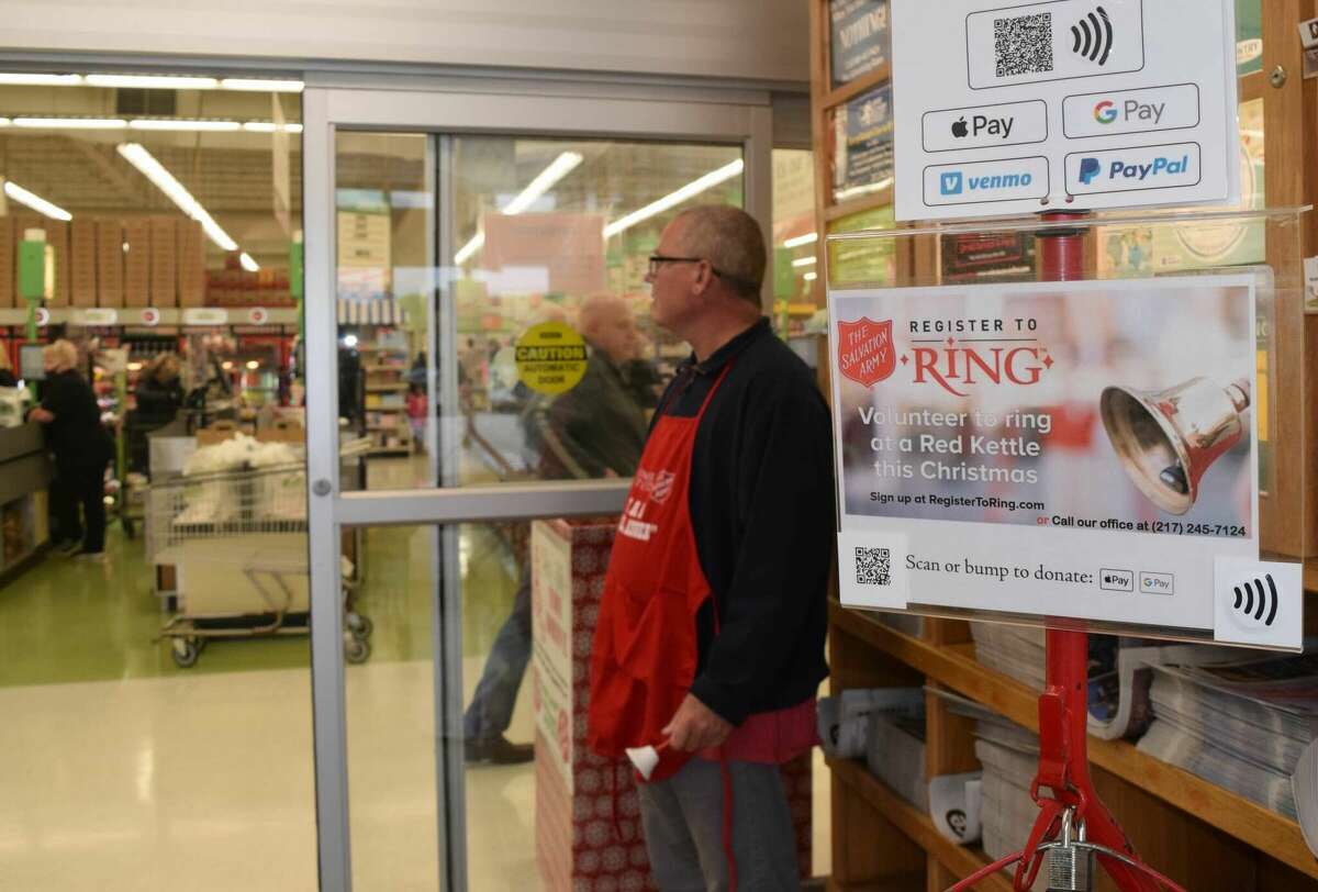 A Salvation Army volunteer rings a bell at County Market during last year's Red Kettle campaign. 