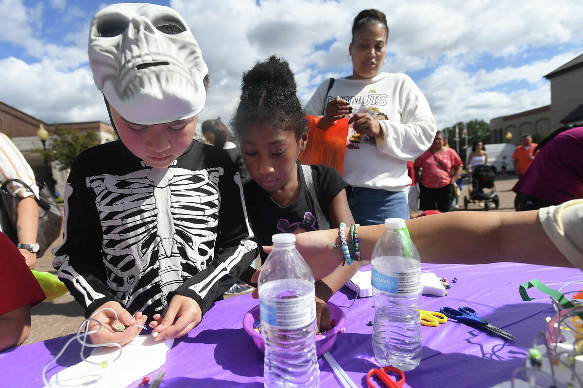 Izayah Rojas and Arionna Battle-Muchala work on a craft during the Art Museum of Southeast Texas' annual Eat A Bug and Family Arts Day Saturday. Nearby, the Texas Energy Museum lawn was filled with dinosaurs and related activities for their Dinosaur Day event. Photo made Saturday, October 22, 2022 Kim Brent/Beaumont Enterprise