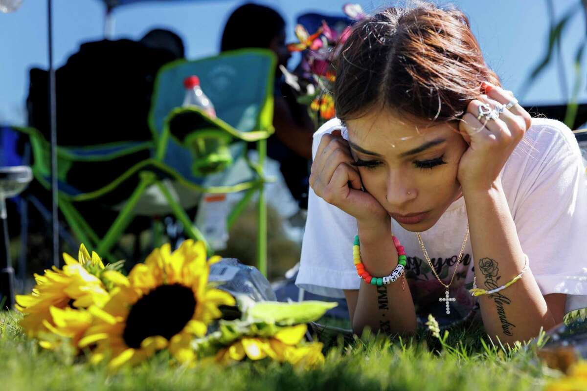 Kalisa Barboza, 18, lies beside her sister Lexi Rubio’s grave in Hillcrest Memorial Cemetery in Uvalde Thursday. Lexi, one of 19 school children and two teachers killed at Robb Elementary on May 24, would have turned 11 on Thursday.