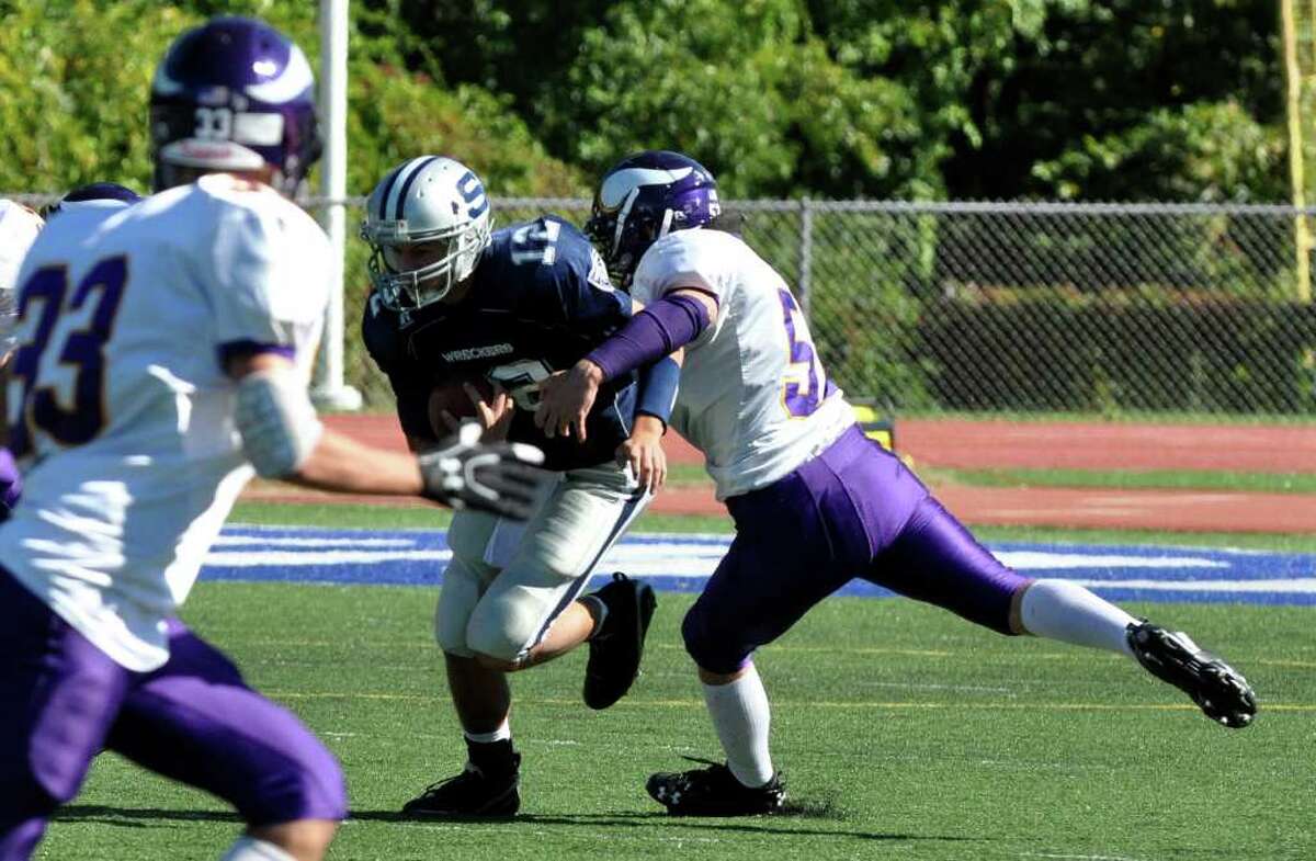 Staples' Chet Pajolek carries the ball as Westhill's Seamus Ronan defends during the first half of the football game at Staples on Saturday, Oct. 9, 2010.