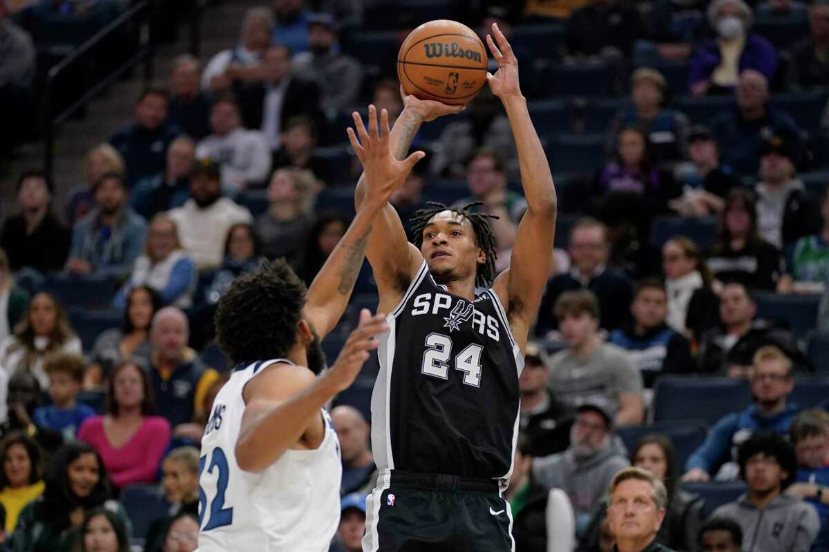 San Antonio Spurs guard Devin Vassell (24) shoots over Minnesota Timberwolves center Karl-Anthony Towns (32) during the second half of an NBA basketball game, Monday, Oct. 24, 2022, in Minneapolis. (AP Photo/Abbie Parr)