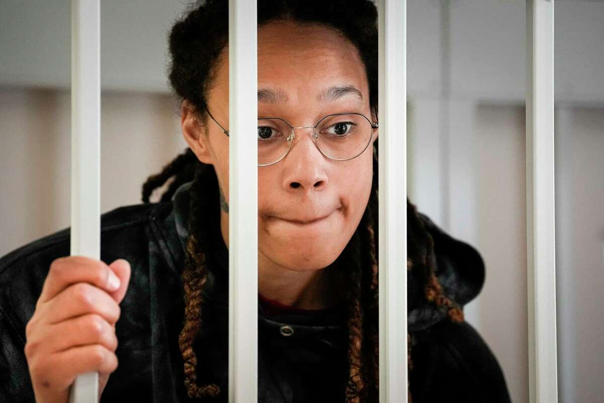 FILE - WNBA star and two-time Olympic gold medalist Brittney Griner speaks to her lawyers standing in a cage at a court room prior to a hearing, in Khimki just outside Moscow, Russia, Tuesday, July 26, 2022. A Russian court has on Tuesday, Oct. 23 started hearing American basketball star Brittney Griner's appeal against her nine-year prison sentence for drug possession.
