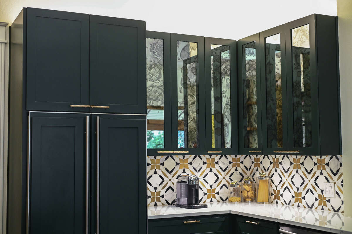 The eye-catching backsplash was done in geometric white, gold and black tile made of several different types of marble.