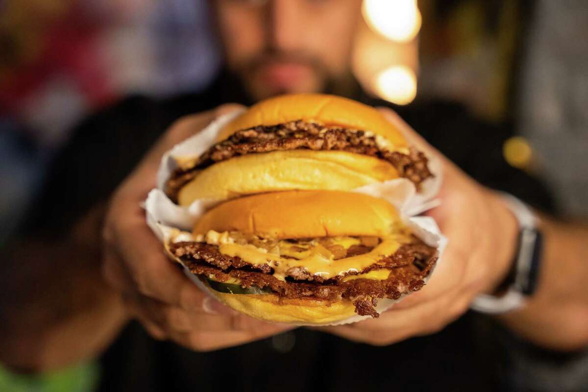 The original Double Smash Burger (two smash patties with American cheese, grilled onions, house-made pickles and bodega sauce on a potato bun) is the signature menu item a Burger Bodega opening at 4520 Washington on Nov. 3.