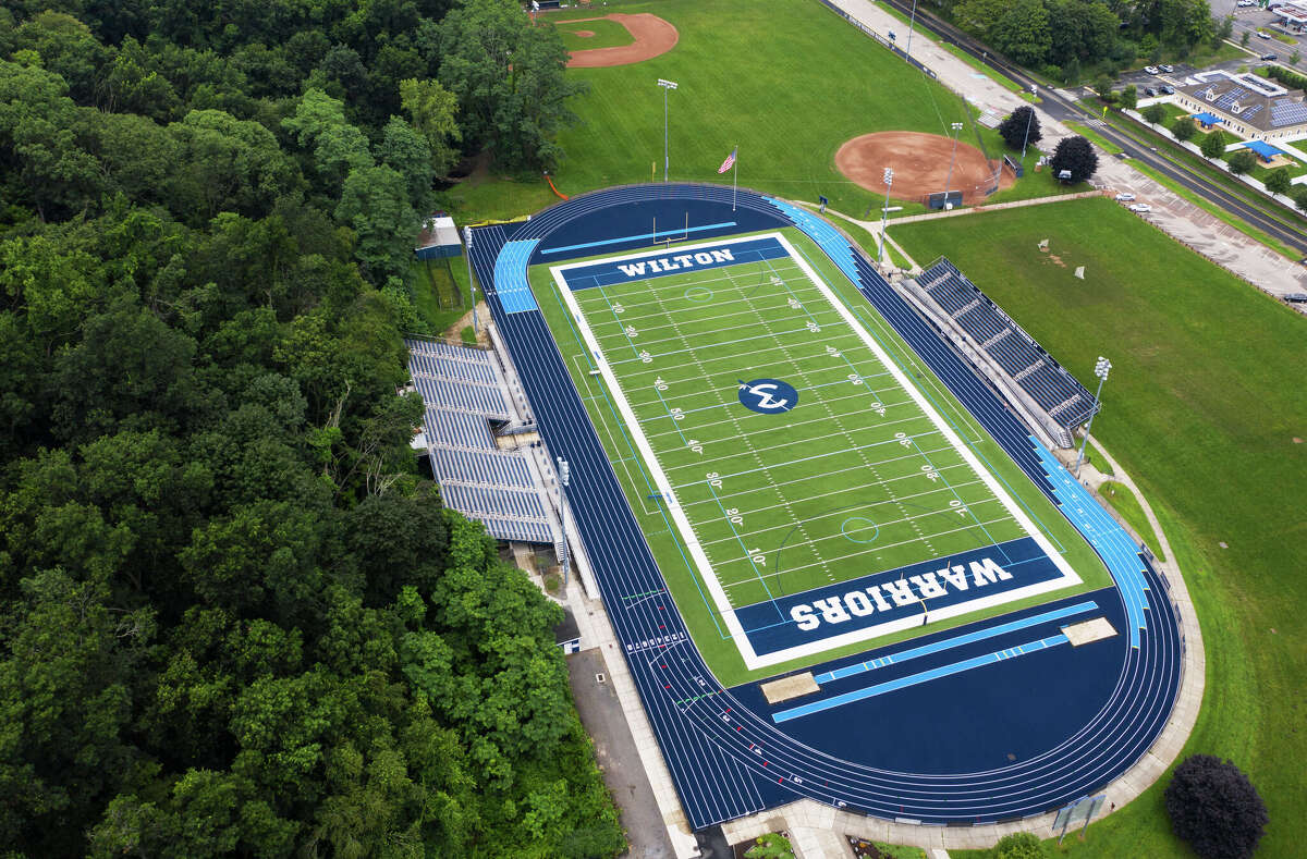 Police said a Bridgeport man was arrested Sunday after punching his child's youth football coach at a game at Wilton High School.