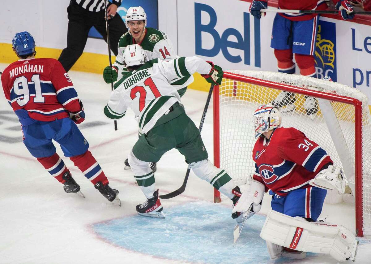Minnesota Wild's Joel Eriksson Ek (14) celebrates his goal against Montreal Canadiens goaltender Jake Allen (34) with teammate Brandon Duhaime during the first period of an NHL hockey game, Tuesday, Oct. 25, 2022 in Montreal. (Graham Hughes/The Canadian Press via AP)