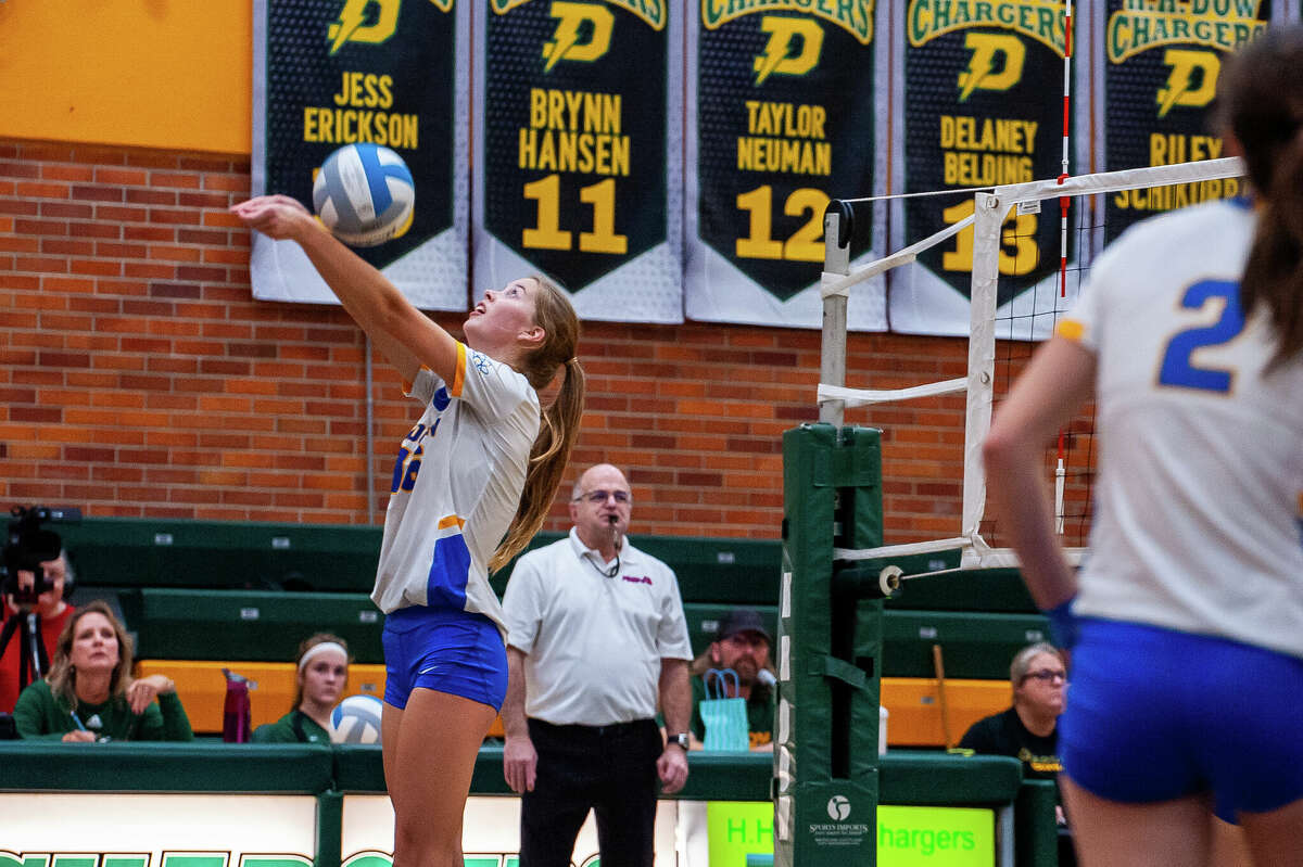Midland High volleyball player Jenna Rekeweg strikes a volleyball at a rivalry meet on Oct. 25 at Dow High School.