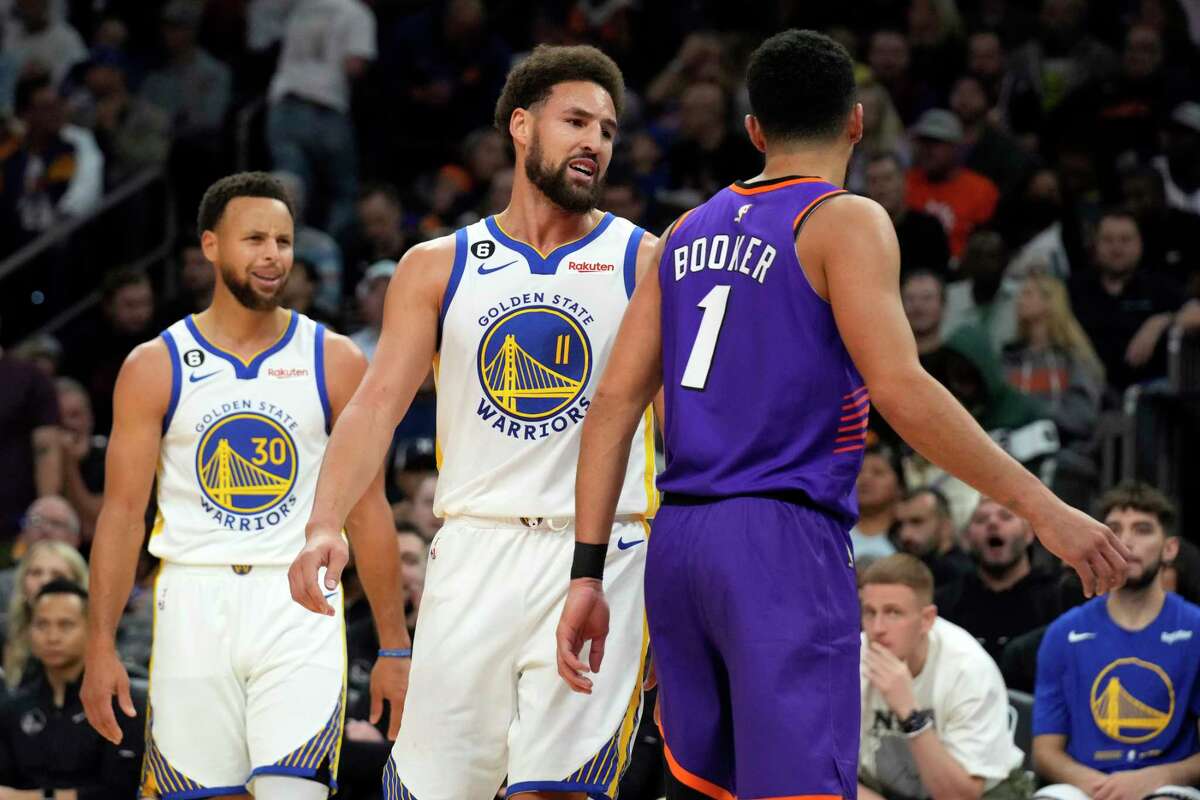 Warriors guard Klay Thompson and Phoenix Suns guard Devin Booker chirp during the second half of Golden State’s loss in Phoenix. Thompson was ejecfted for the first time in his career.