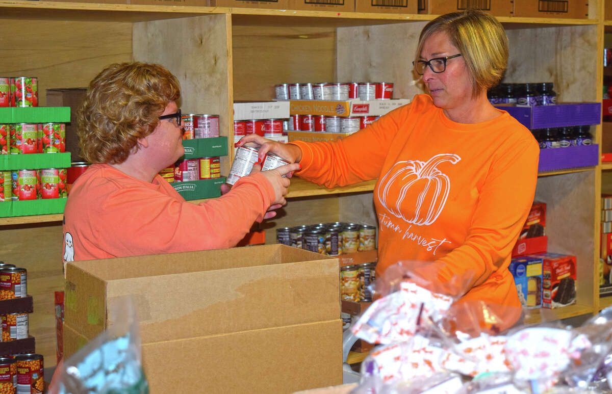 Kelsey (left) and Melissa Hall pack a box with canned goods and other non-perishable food items at Jacksonville Food Bank, 316 E. State St. Melissa Hall, the food pantry's administrator, said things are expected to be much busier once the holiday season gets under way.
