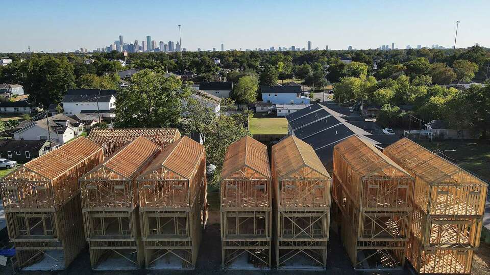 Drone photo of newly built homes with downtown Houston's skyline in the background on 35th street on Wednesday, Oct. 26, 2022 in Houston. Originally there were four homes on the corner lot, soon there will be eight.