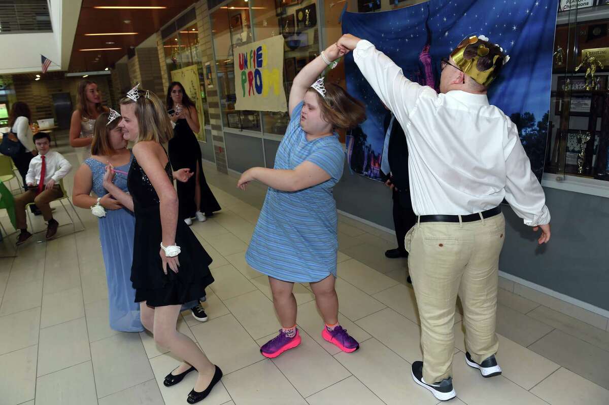 Joey Conover, right, of Guilford twirls Jane Jensen of Madison at a unified prom at Guilford High School.