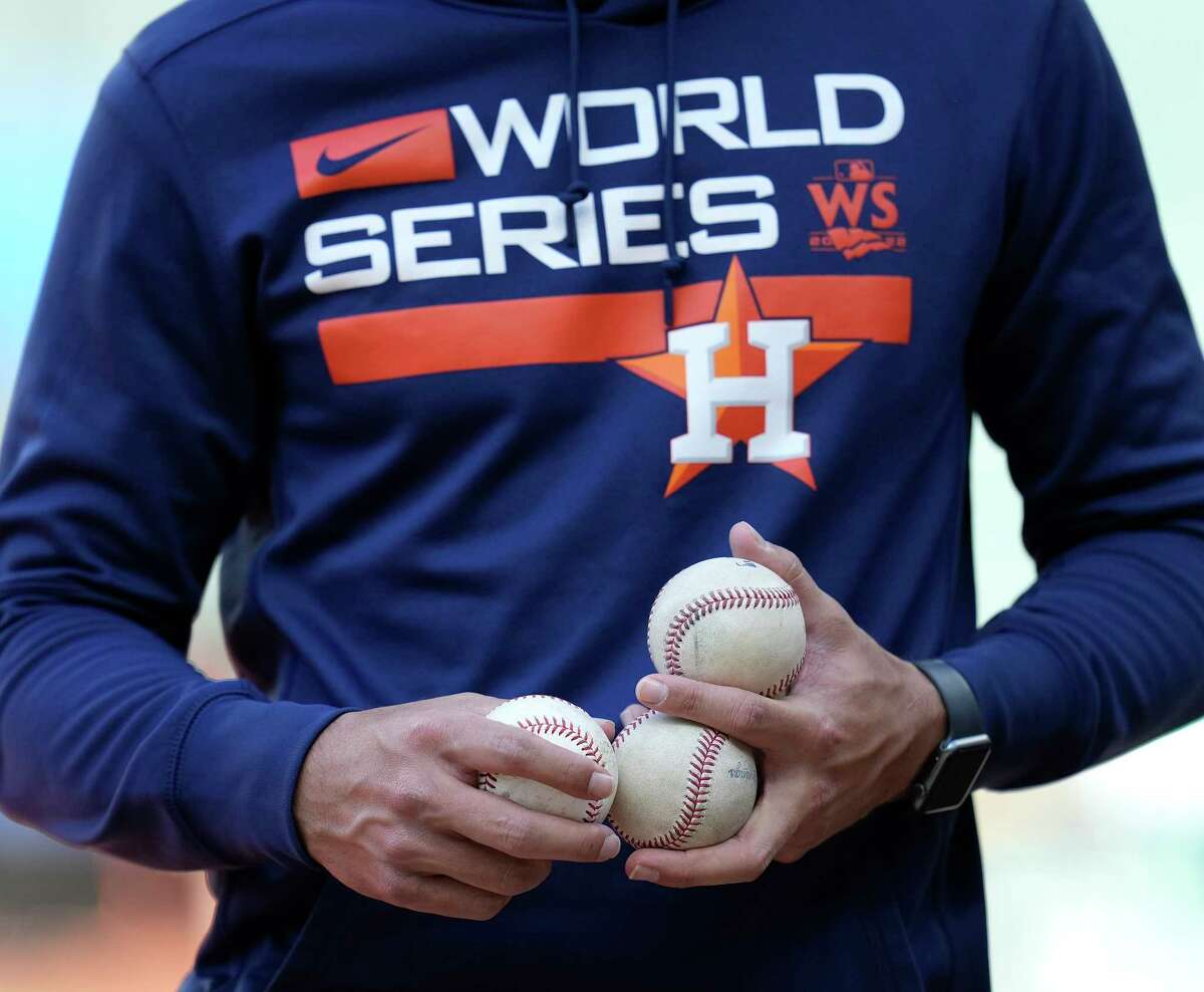Houston Astros Jason Bell, fundamentals coordinator, holds a handful of balls during team workouts ahead of Game 1 of baseball’s World Series at Minute Maid Park on Thursday, Oct. 27, 2022 in Houston.