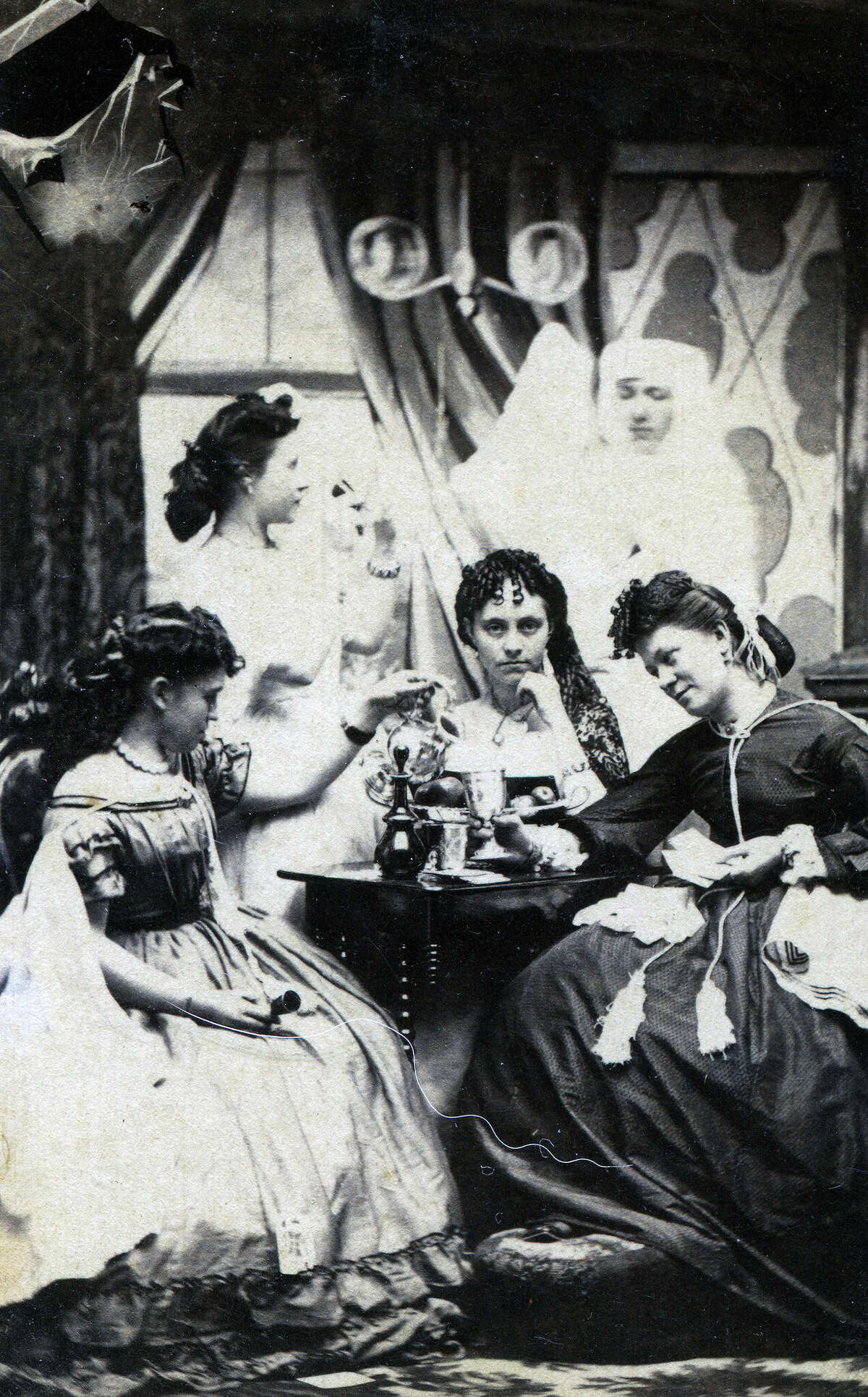 A group of young women meeting in a parlor with a ghostly figure in the background in Lowville, New York.
