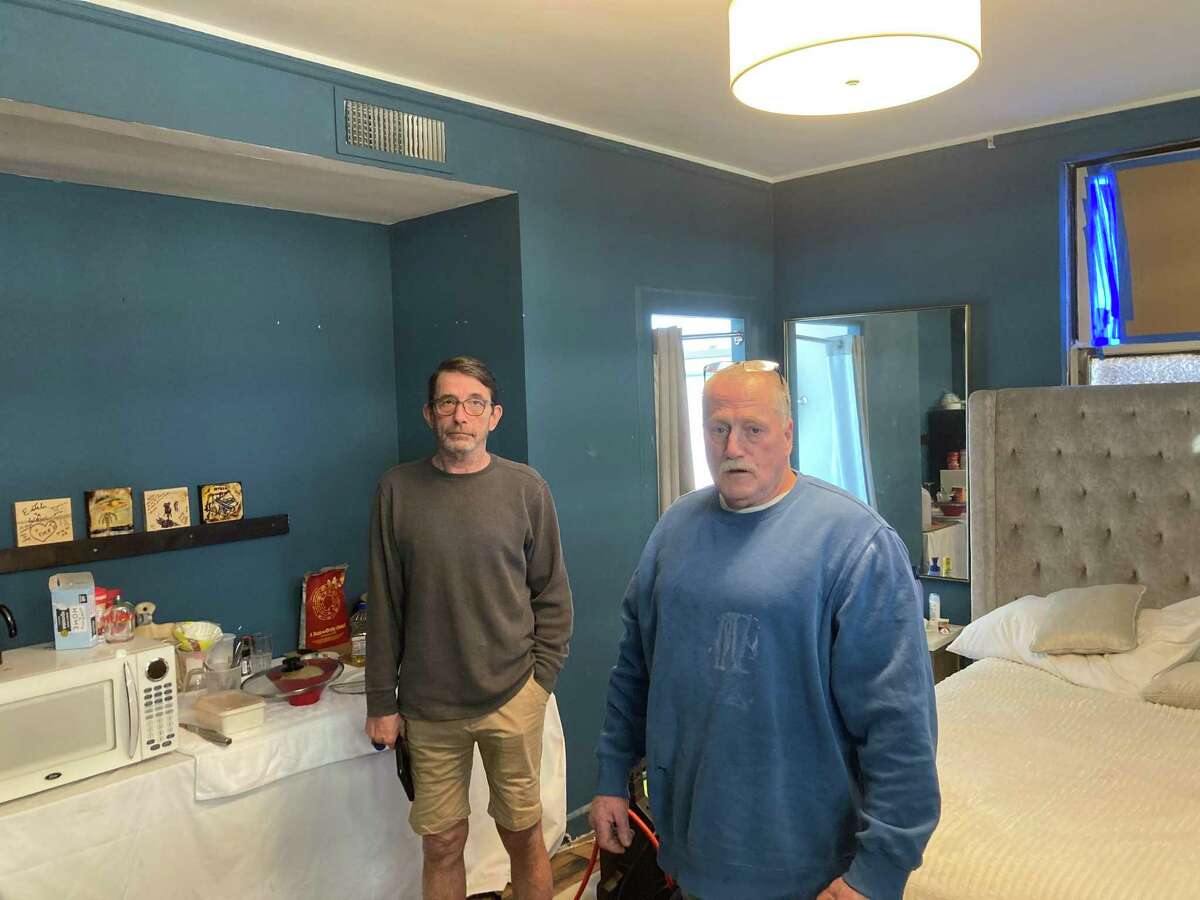 Brian Loop, left, and Wayne Roberts in Room 1420 of the Beacon Grand above Union Square. Roberts has been living here for 13 months while working on renovations to the hotel. He’s been asked to leave but refuses until he is paid in full.