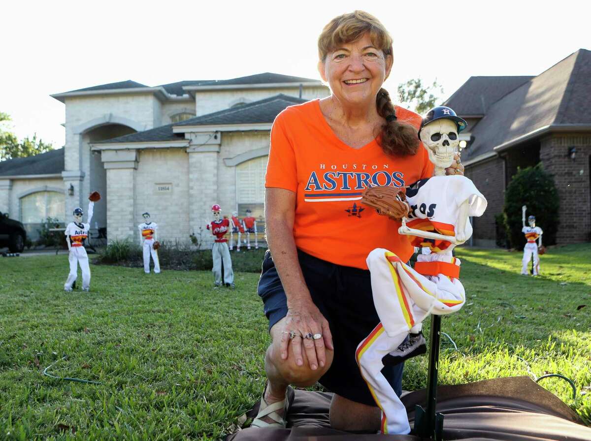 Patty Norman poses for a photo with her World Series skeleton baseball scene between the Houston Astros and Philadelphia Phillies at her home, Thursday, Oct. 28, 2022, in Willis. Patty and her husband, Wayne, are avid baseball fans, love the Astros and decided to have some fun with the annual Halloween decorating of their Point Aquarius yard.