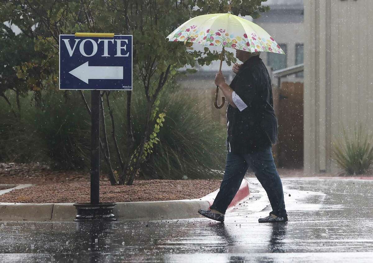 File photo of an election worker walking through the rain to the Gillespie County elections office as early voting began Monday. The National Weather Service reported strong storms began moving into the San Antonio area Friday morning. 
