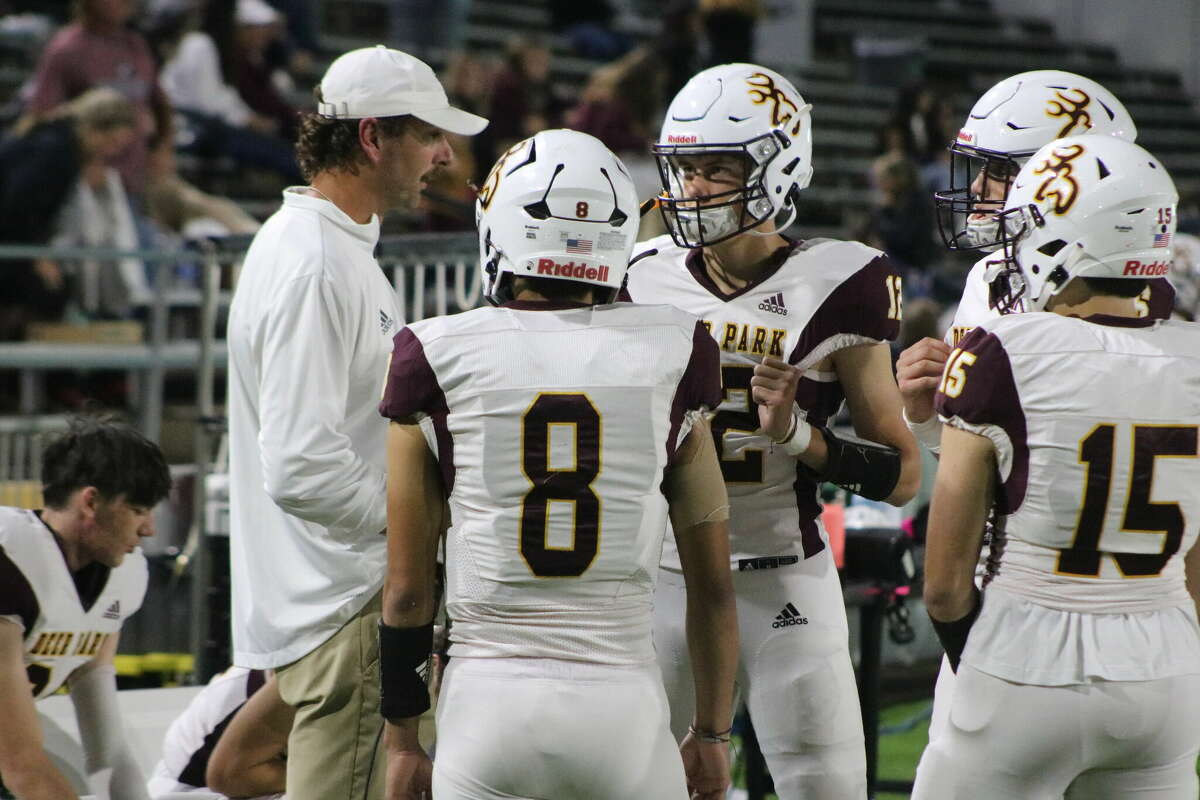 Deer Park quarterbacks coach Ryan Hrncir discusses strategy with the team's four quarterbacks. All four had a hand in setting an all-time scoring record against Rayburn, a record that goes all the way back to 1966.