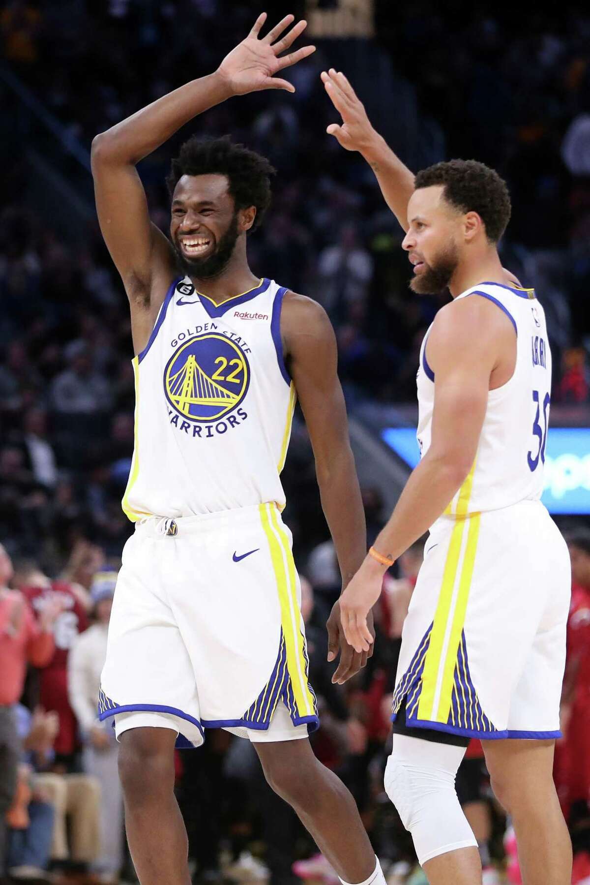 Golden State Warriors’ Andrew Wiggins and Stephen Curry celebrate a Curry 3-pointer in 4th quarter of Warriors’ 123-110 win over Miami Heat in NBA game at Chase Center in San Francisco, Calif., on Thursday, October 27, 2022.