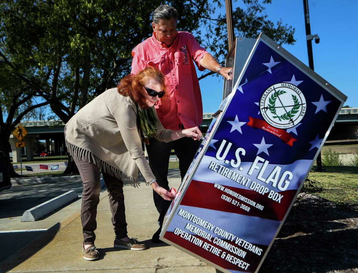 Trish Almond with the Montgomery County Veteran’s Memorial Commission unlocks a new receptacle for citizen to deposit their used American flags with the help of U.S. Army veteran Floyd Stewart at the entrance to the Montgomery County Veterans Memorial Park, Thursday, Oct. 27, 2022, in Conroe. The commission is hoping the metal receptacles around Conroe will encourage citizens to properly discard their old flags in them, where they will be properly retired every 90 days.