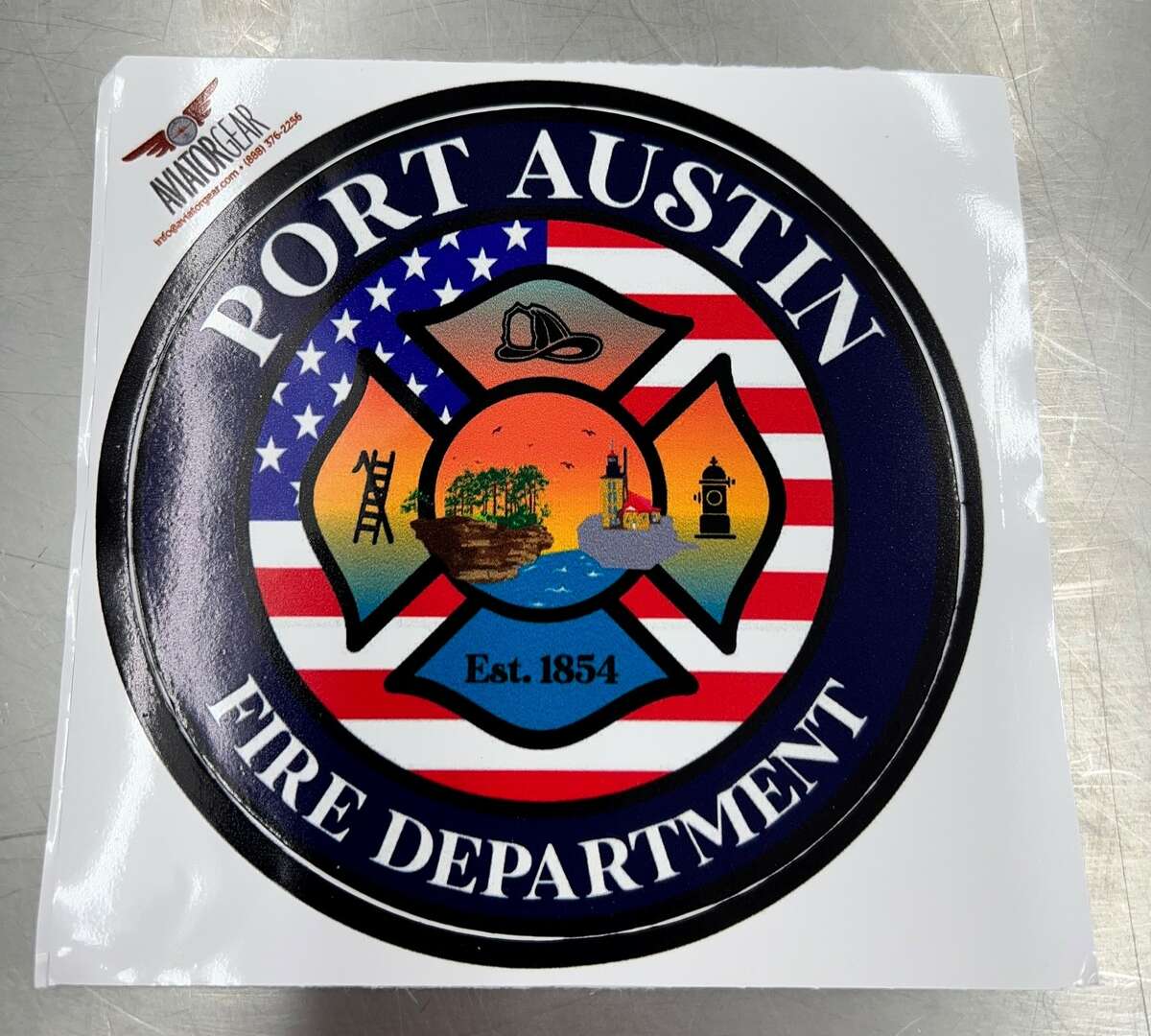 Port Austin Fire Department stickers and T-shirts are up for grabs at Port Austin Hardware.