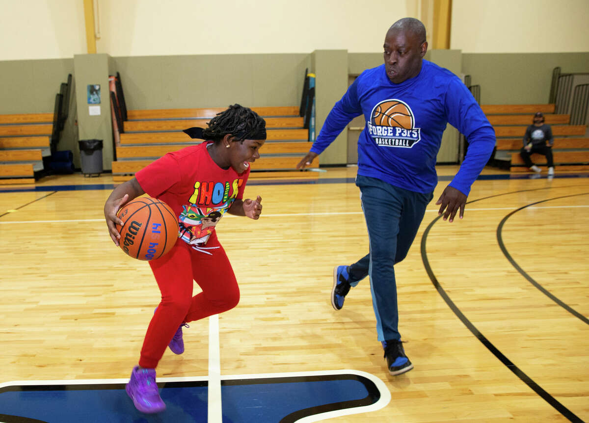 Chris Williams and Aulayla Clark play one-on-one during an "On The Right Path" youth basketball program, developed and led by former Houston Rockets assistant coach Brett Gunning, Wednesday, Oct. 26, 2022, at The FORGE for Families in Houston. 