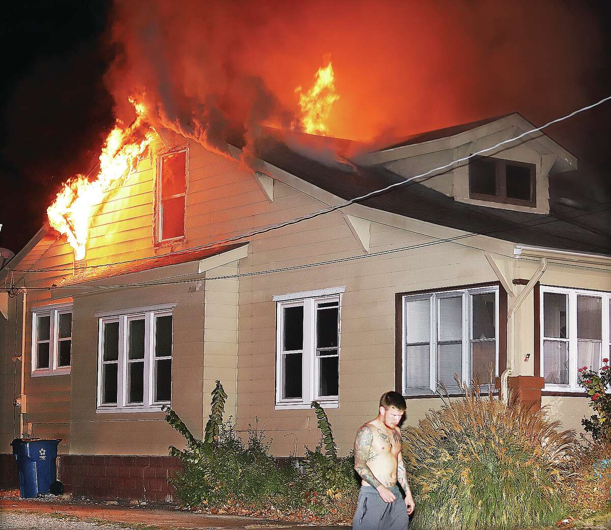 John Badman|The Telegraph Flames roar from the upstairs of a house at 3308 Brown Street in Alton early Friday morning. The house, which is for sale and has been on the market for over a month, suffered extensive damage in the upstairs rear and water and smoke damage throughout.