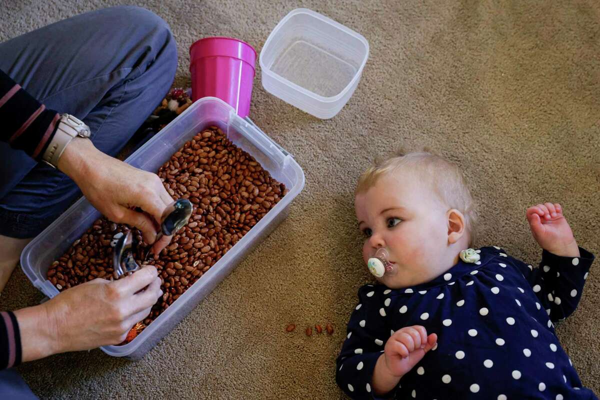 Lucy Landman watches as occupational therapist Kate Delgado taps spoons together during a session together at her home in Danville, Calif. on Wednesday, Oct. 27, 2022.