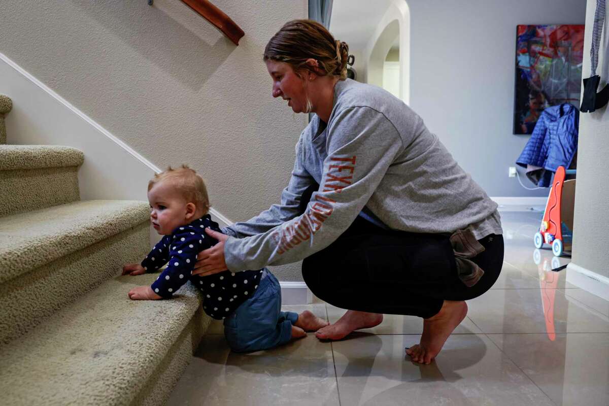 Nanny Hannah Thurman helps Lucy Landman up the stairs at her home in Danville, Calif. on Wednesday, Oct. 27, 2022.