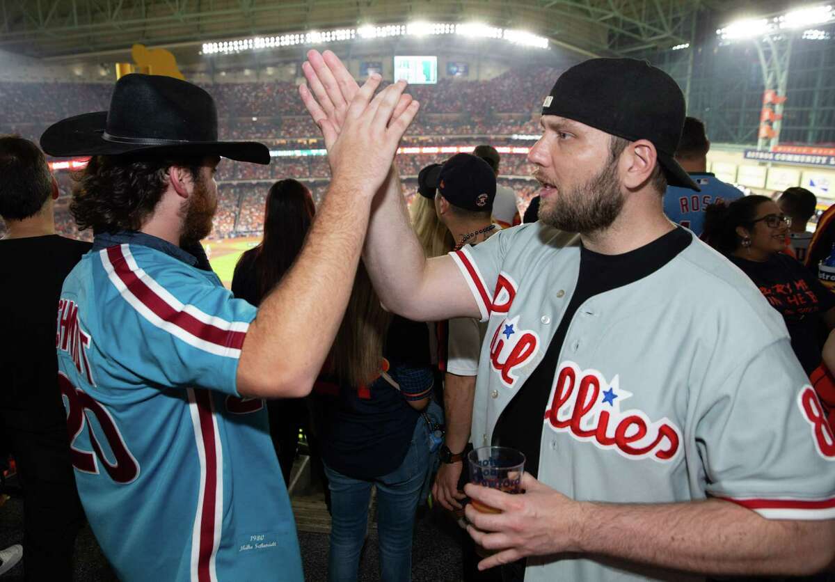 Philadelphia Phillies fans Luke Sobo, of Dallas, and Trent Powers, of Chicago, high-five when Houston Astros’ Jose Altuve was struck out swinging during Game 1 of World Series 2022 Friday, Oct. 28, 2022, at Minute Maid Park in Houston.