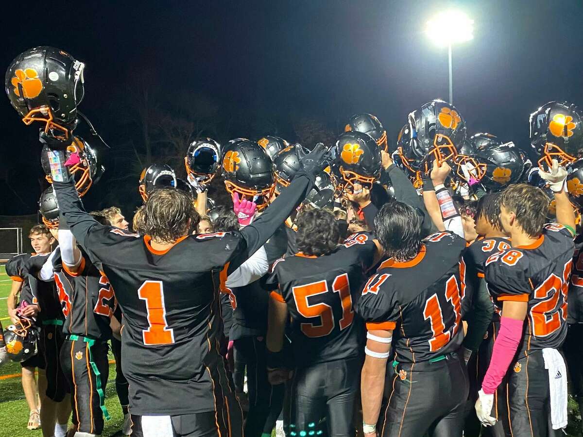 Members of the Ridgefield football team celebrate after defeating Wilton Friday, Oct. 28, 2022.