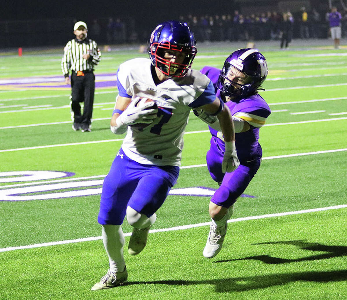 Carlinville's Jack Rouse (left) gets past Williamsville's Nolan Bates to score on a 7-yard TD run in the first quarter in a Class 3A first-round playoff game Friday night at Williamsville.