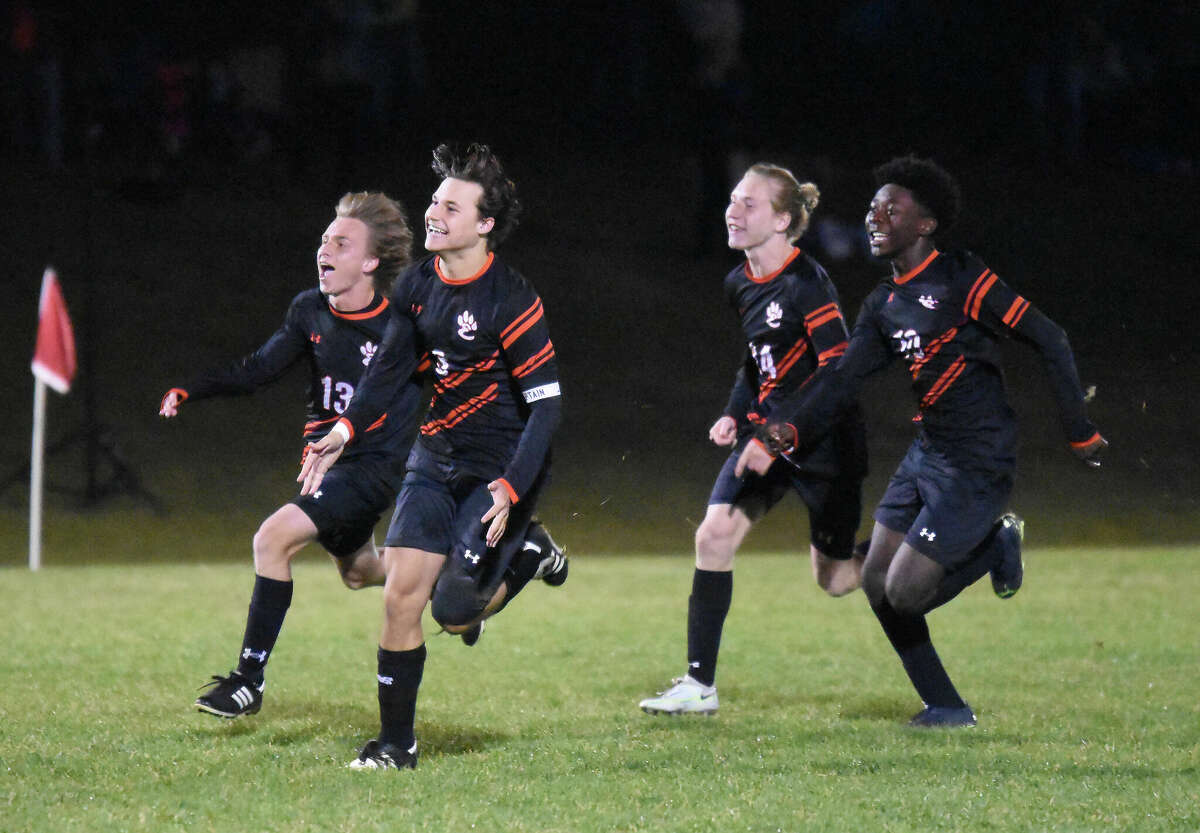 Edwardsville's Jonas Mahler, Tyler Dacus, Nathan Loftus and Axton Anom celebrate the game-winning PK by Blye Brickman against Joliet West on Friday in the Class 3A Moline Sectional championship game inside the Moline Soccer Bowl in Moline.