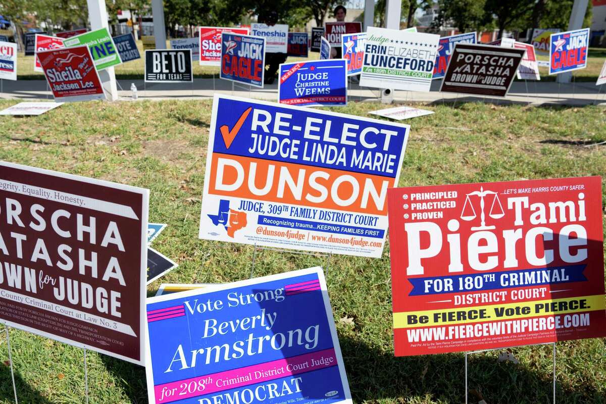 Signs blanket the outside of the West Gray Metropolitan Multi-Service Center in Houston, TX on Thursday October 27, 2022 during early voting for the midterm elections.