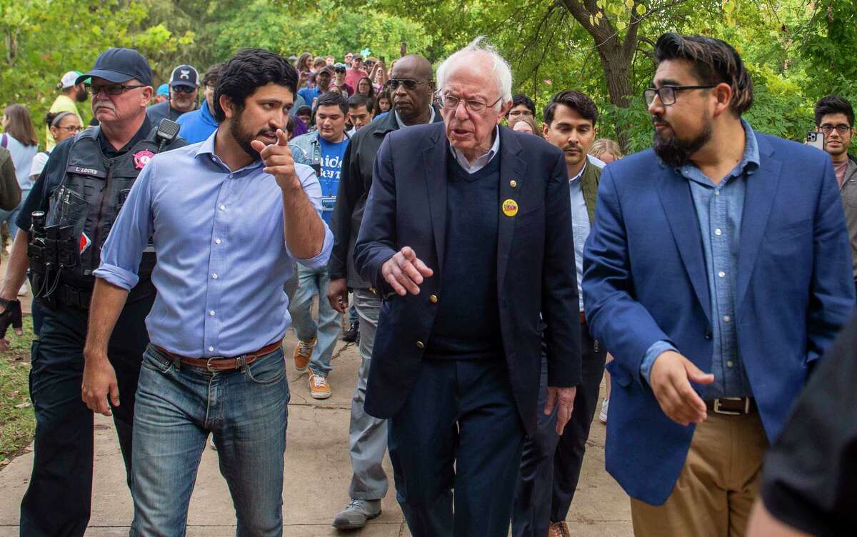 Democratic nominee for Texas Congressional District 35 , Greg Casar, left, and United States Senator Bernie Sanders (D-Vermont), center, walk to the polls followed by Texas State University during a get out the vote rally at Sewell Park in San Marcos on Sat.October, 29, 2022.